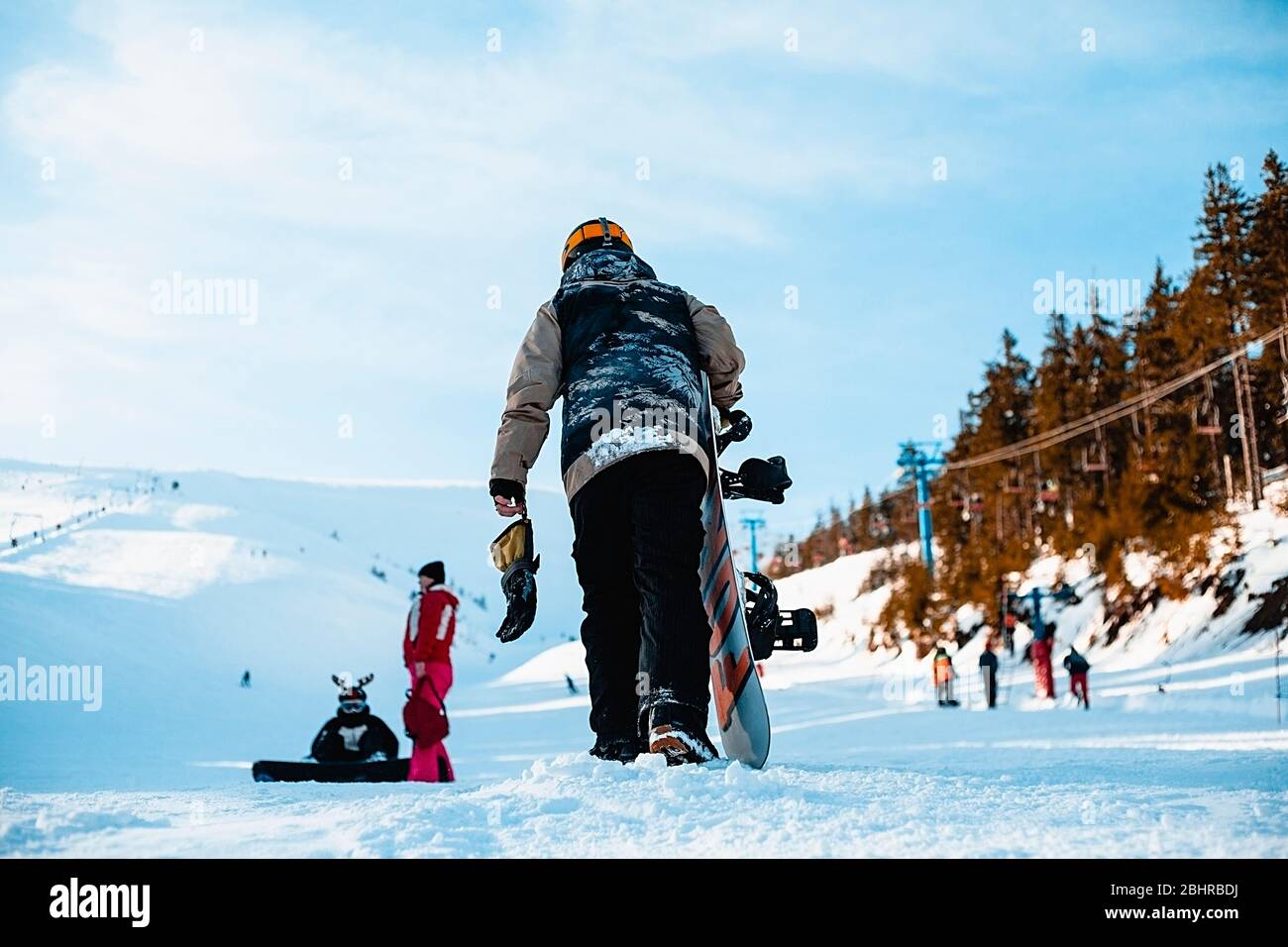 Blick auf eine Skipiste mit Snowboardern auf der Piste und im Vordergrund. Stockfoto