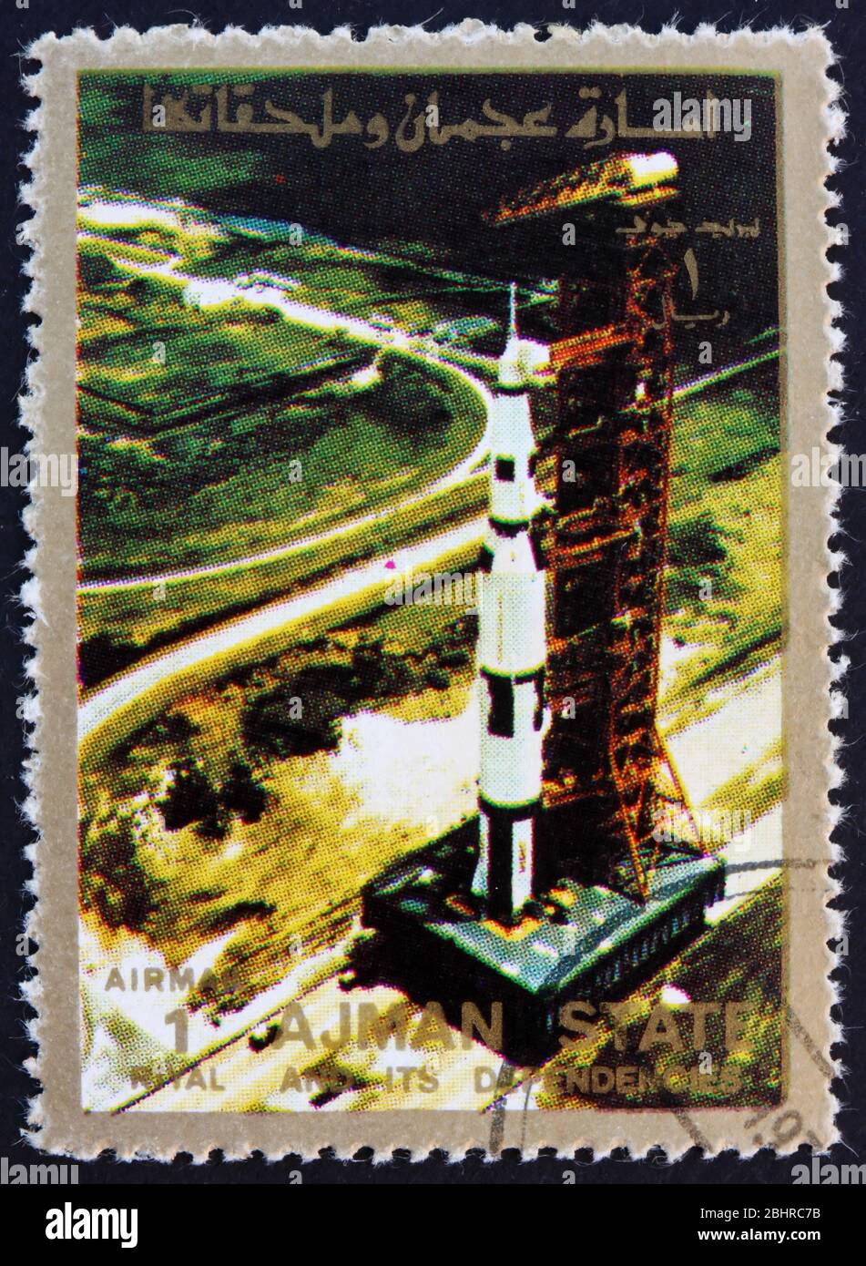 AJMAN - UM 1973: Eine im Ajman gedruckte Marke zeigt Roll Out of Saturn 5 auf der Startfläche, Mondlandung, Apollo 11, um 1973 Stockfoto