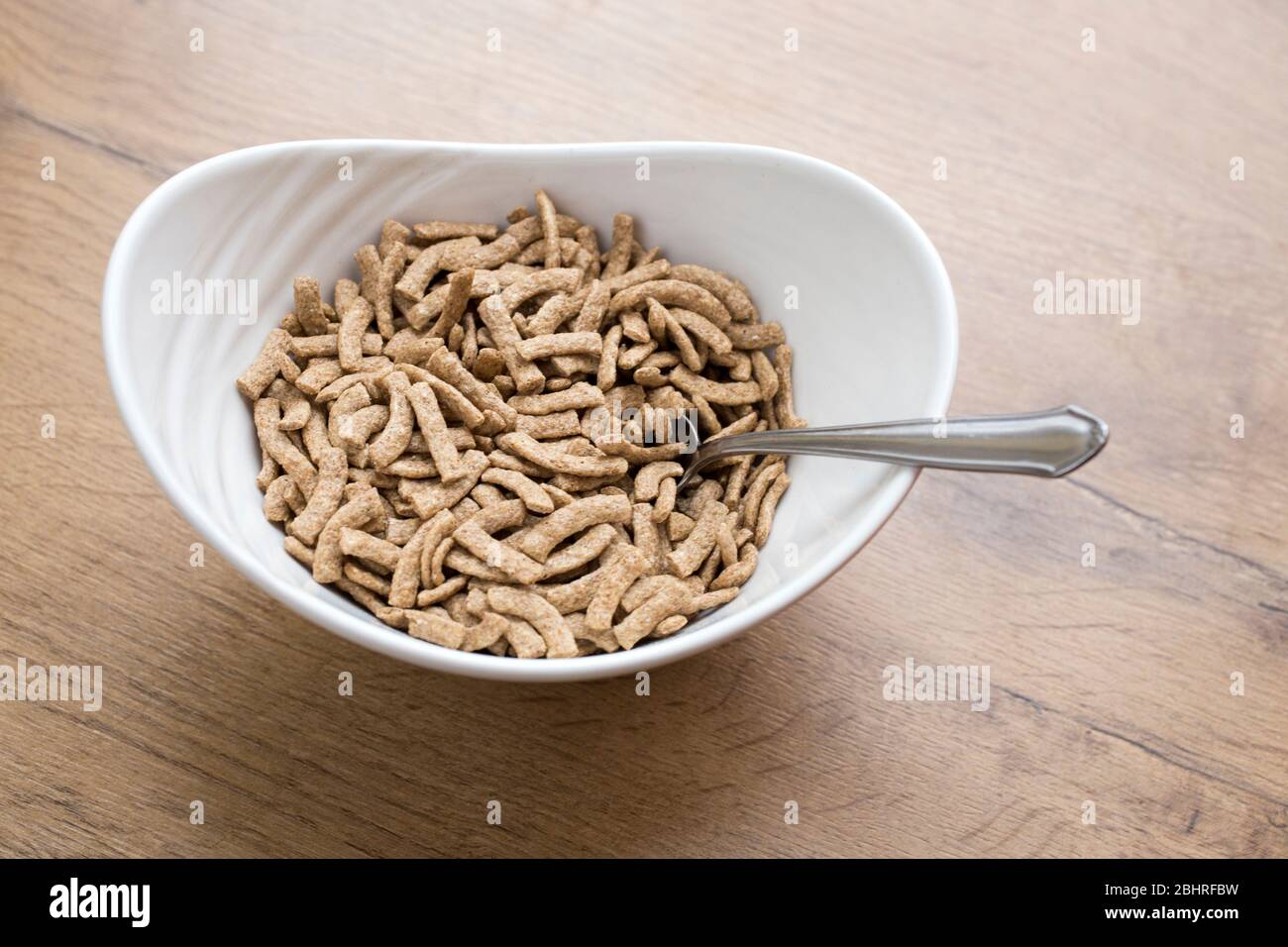 Weiße Schale mit gesunden Cerealien auf Holzhintergrund Stockfoto