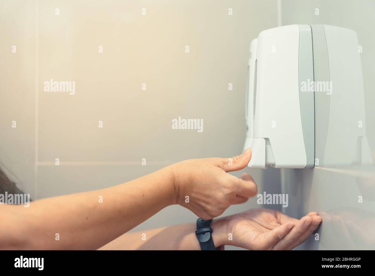 Nahaufnahme der Hände von Frauen, die Seife mit Flüssigseifenpresse in der Toilette pumpen, um die Hände zu waschen. Konzept für Reinigung und Gesundheitswesen. Stockfoto