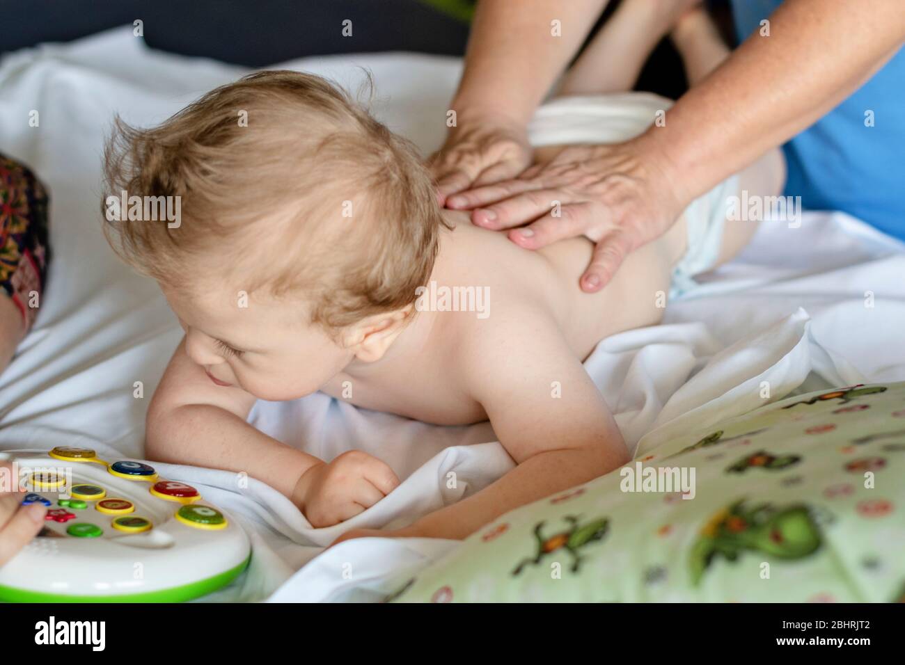 Baby mit Rückenmassage in einem Rehabilitationszentrum. Kleines Kind auf Therapie. Masseur massieren ein Baby. Stockfoto
