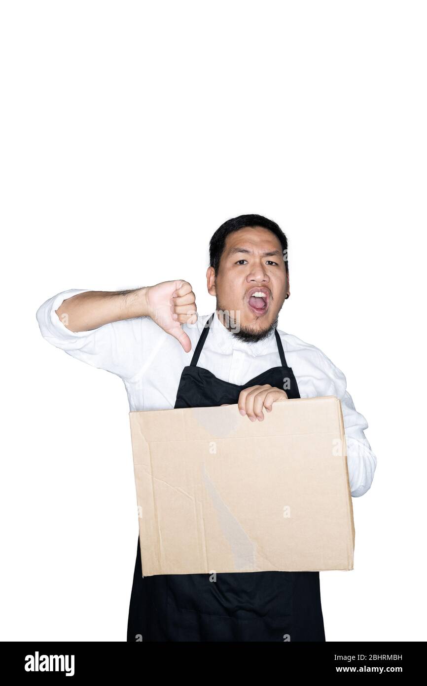 Bärtige asiatische Männer Kellner, Koch in schwarzer Schürze gekleidet hält Pappe und zeigt Daumen nach unten in weißem Hintergrund.das Konzept des Protests, attenti Stockfoto