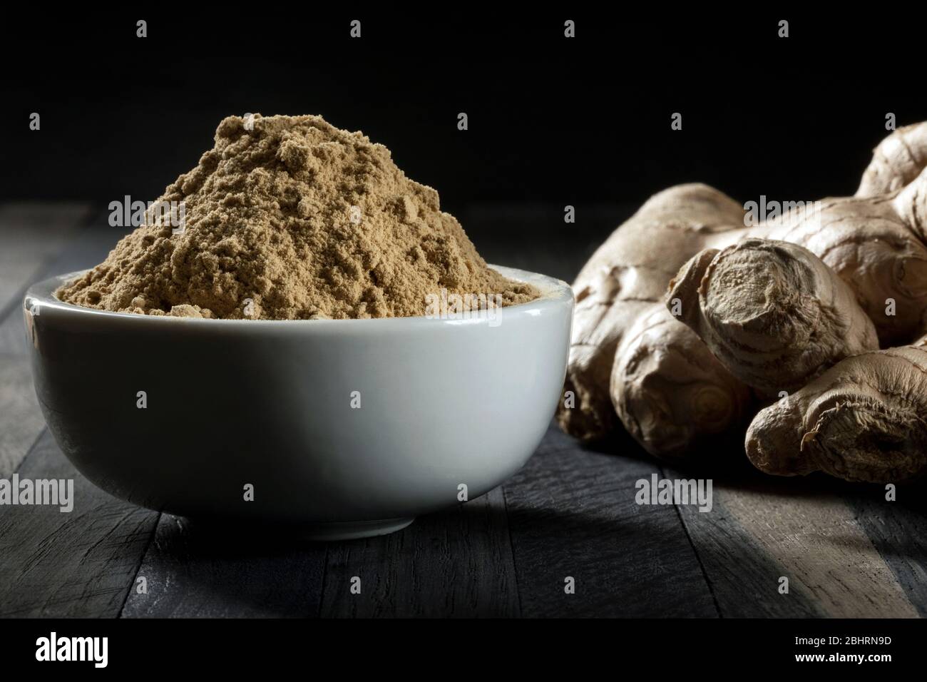 Ingwerwurzel in einer Schüssel auf einem Holztisch gemahlen. Stockfoto