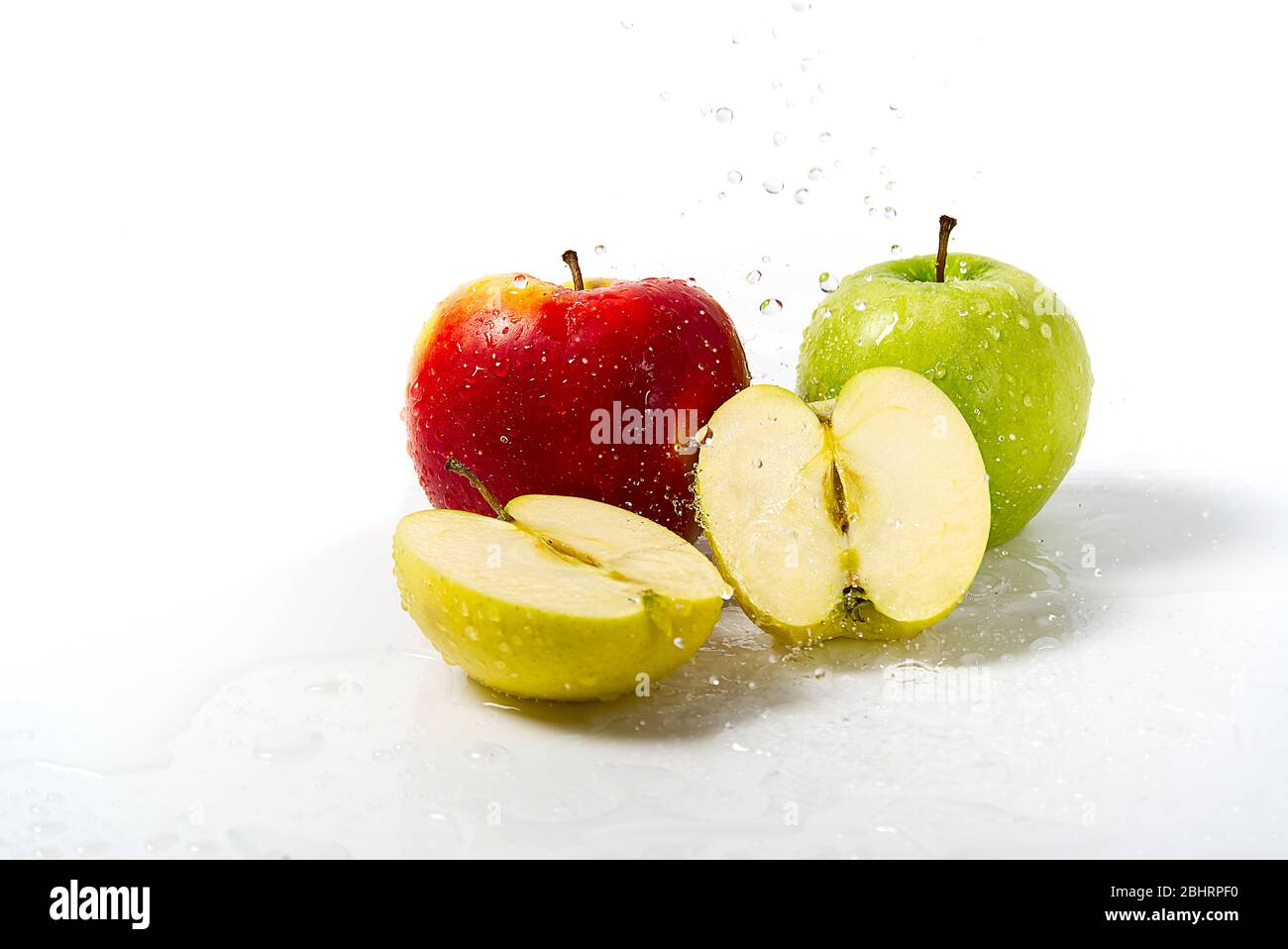 Drei Äpfel mit Wasserspritzer. Drei Äpfel rot, grün und gelb mit Warer Spritzer auf weißem Hintergrund Stockfoto