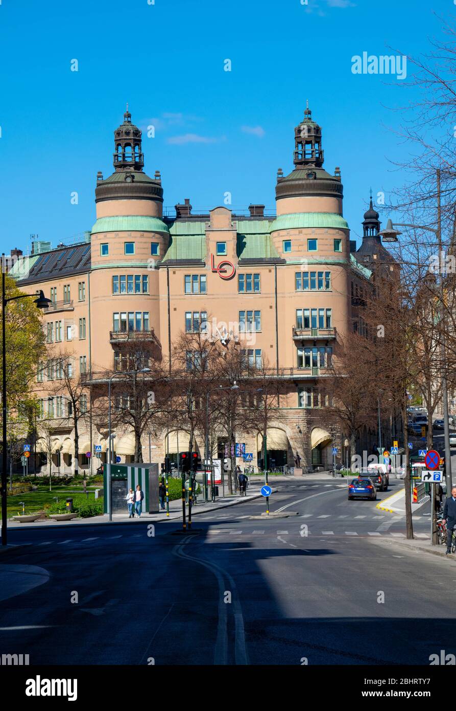 Verkehr vor dem berühmten Gebäude, bekannt als "LO-borgen" im Zentrum von Stockholm. Seit 1926 Sitz des schwedischen Gewerkschaftsbundes. Stockfoto