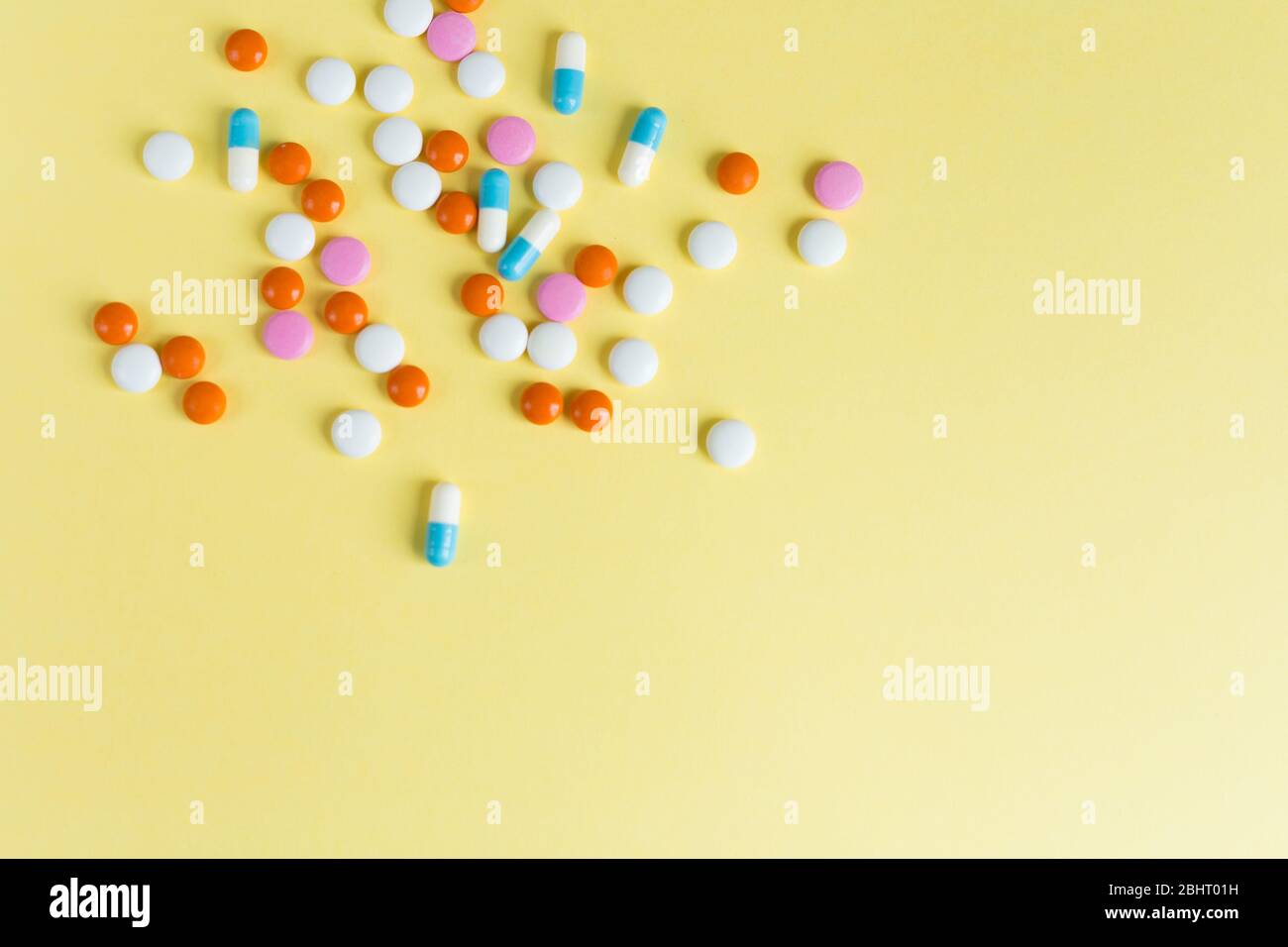 Verschiedene verschiedene Medikamente Pillen, Tabletten auf gelbem Hintergrund. Viele Pillen und Tabletten mit Platz für Text. Gesundheitswesen. Draufsicht. Kopierbereich Stockfoto