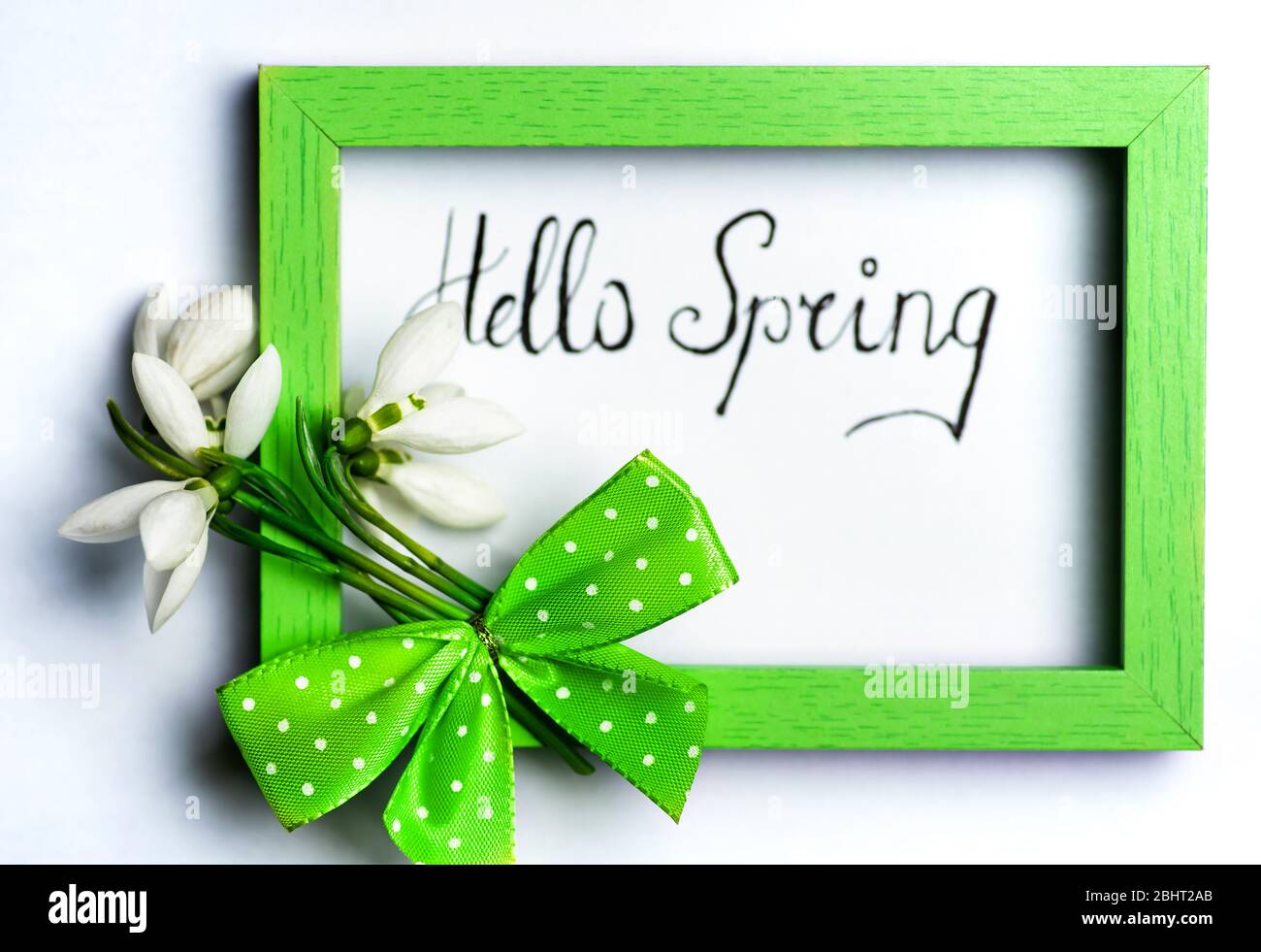 Frischer Schneeglöckchen Bouquet mit einem Band in einem Holzrahmen auf Weiß Stockfoto