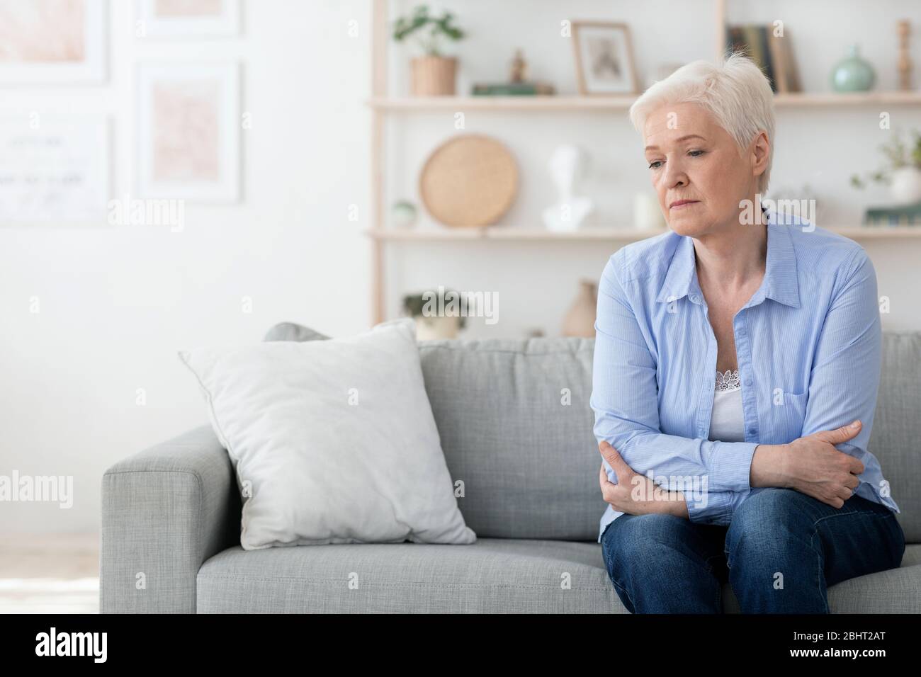 Porträt Der Depressiven Lonely Senior Frau Sitzt Auf Der Couch Zu Hause Stockfoto