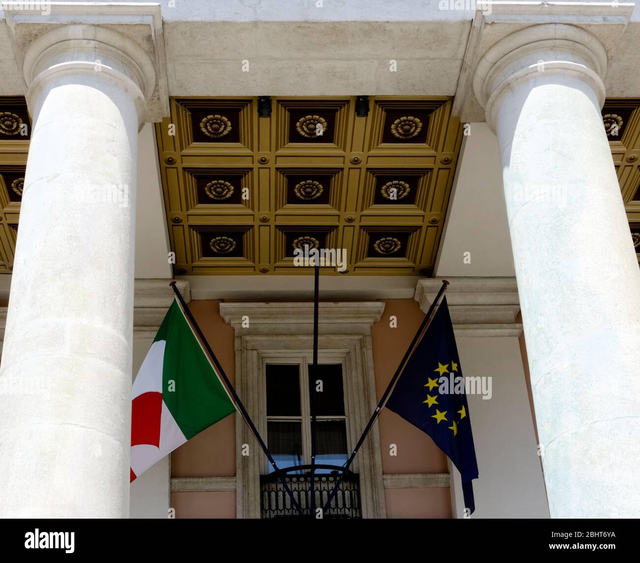 Italienische und europäische Flaggen winken. Sitz der Industrie-, Gewerbe- und Landwirtschaftskammer Venezia Giulia. Neoklassizistisches Gebäude Triest, Italien Stockfoto