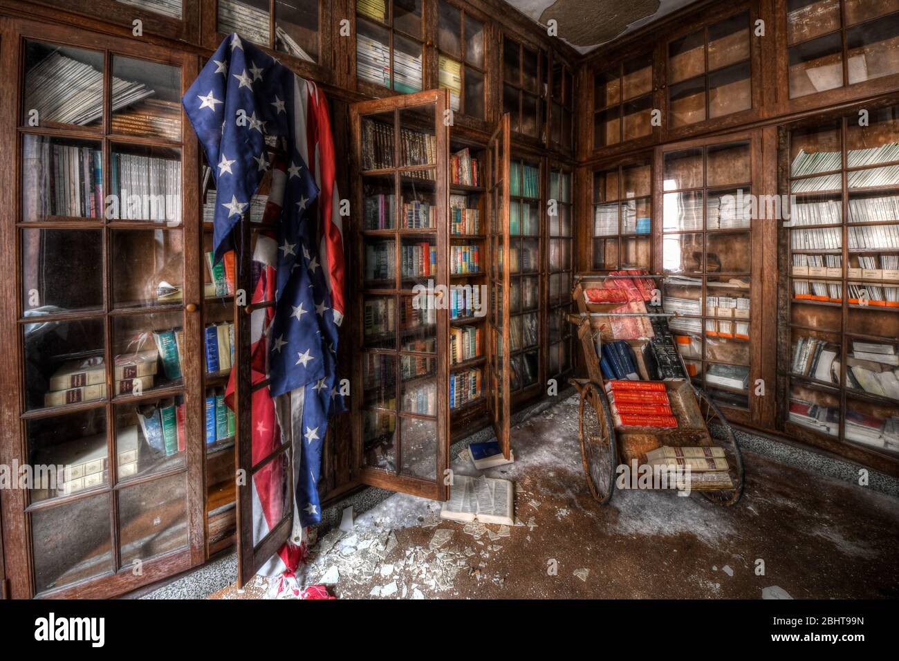 Bücher und amerikanische Flagge in der alten medizinischen Bibliothek eines verlassenen Krankenhauses Stockfoto