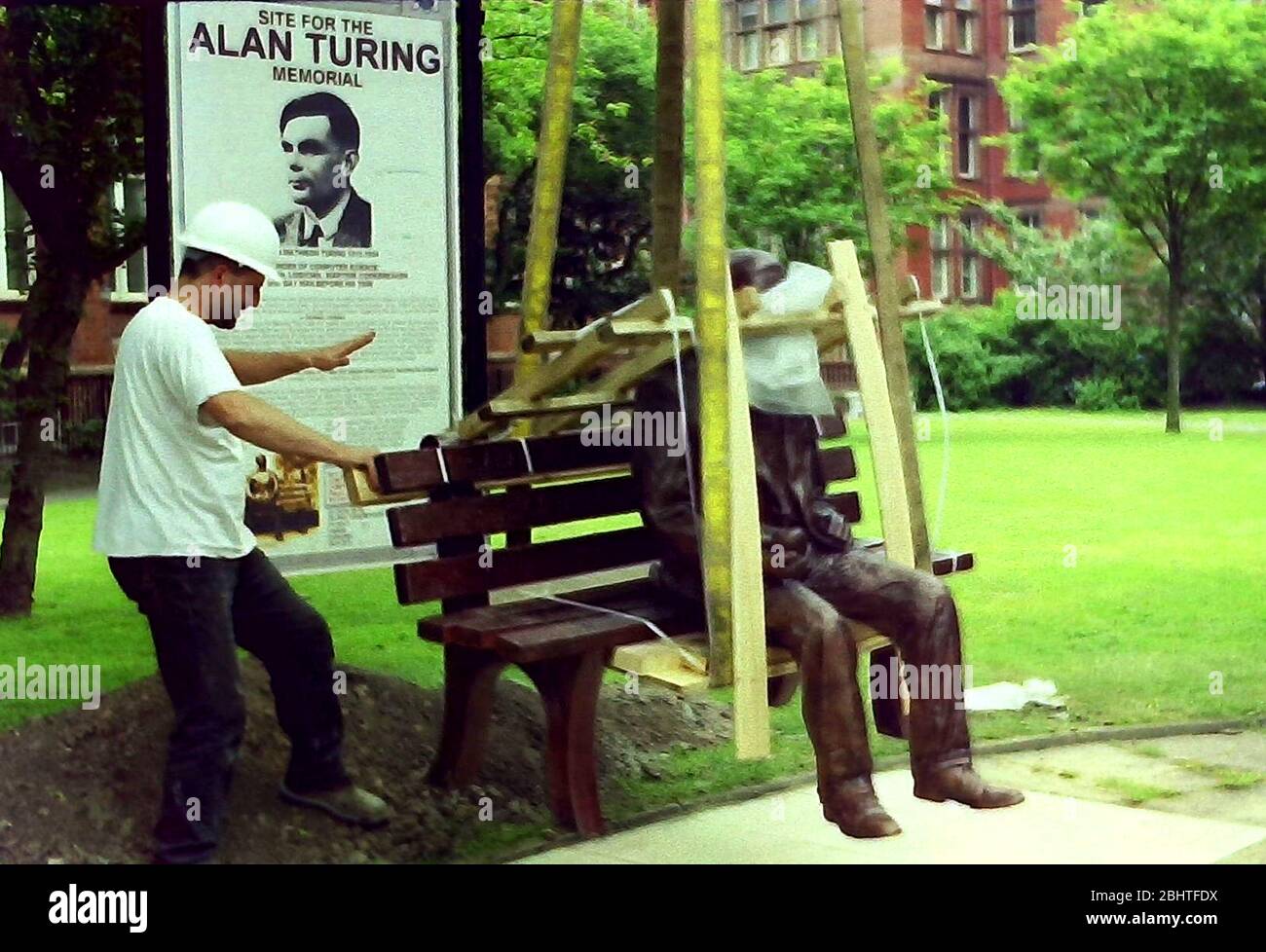 Installation der Alan Turing-Statue und -Gedenkstätte, Sackville Gardens, Manchester, großbritannien, im Jahr 2001. Die Statue wurde später am 23. Juni 2001, dem Geburtstag von Turing, offiziell enthüllt. Glyn Hughes, industrieller Bildhauer und Gestalter der Statue, überwacht den Betrieb. Alan Mathison Turing OBE war ein englischer Mathematiker, Informatiker, Logiker und Kryptanalyst. Im 2. Weltkrieg leitete er ein Team, das dafür verantwortlich war, deutsche Cipher der Enigma-Maschine zu brechen. Turing hatte damals Einfluss auf die Entwicklung der Informatik an der University of Manchester. Stockfoto