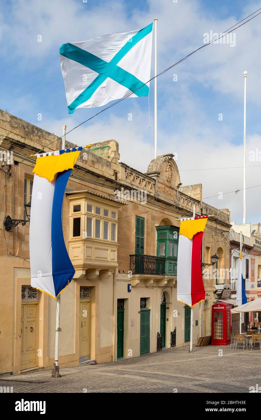 Flaggen und traditionelle rote Telefonbox, Marsaxlokk, Malta Stockfoto