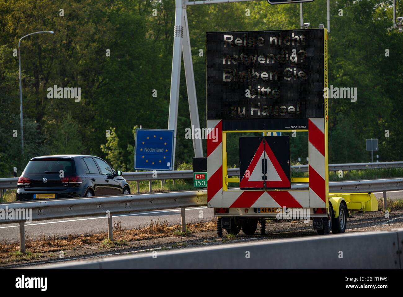 Deutsch-Niederländische Grenze bei Emmerich-Elten, Autobahn A3, Signalboard bittet Reisende, nur notwendige Reisen in die Niederlande zu machen, Auswirkungen des coron Stockfoto