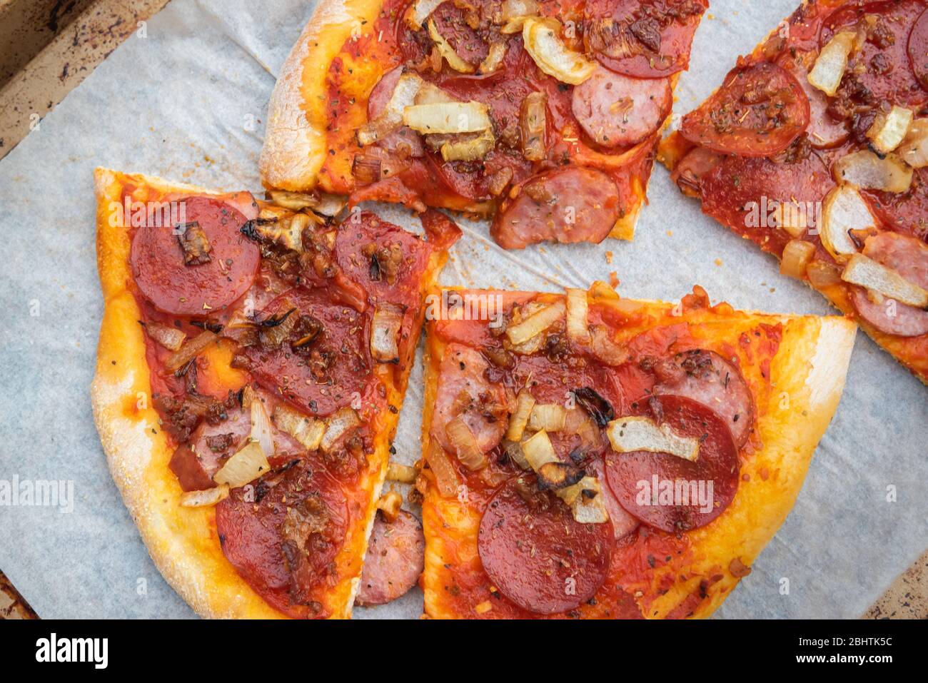 Scheiben von hausgemachten dünnen Kruste Käse freie Pizza mit Wurst und karamellisierten Zwiebeln Stockfoto