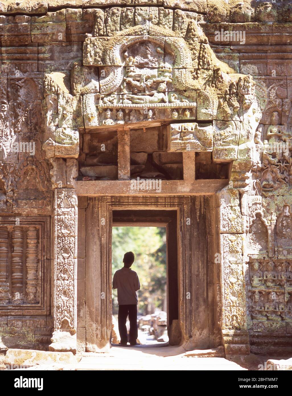 Kleiner Junge, der in einem alten Tor steht, Ta Prohm Tempel, Siem Reap, Königreich Kambodscha Stockfoto