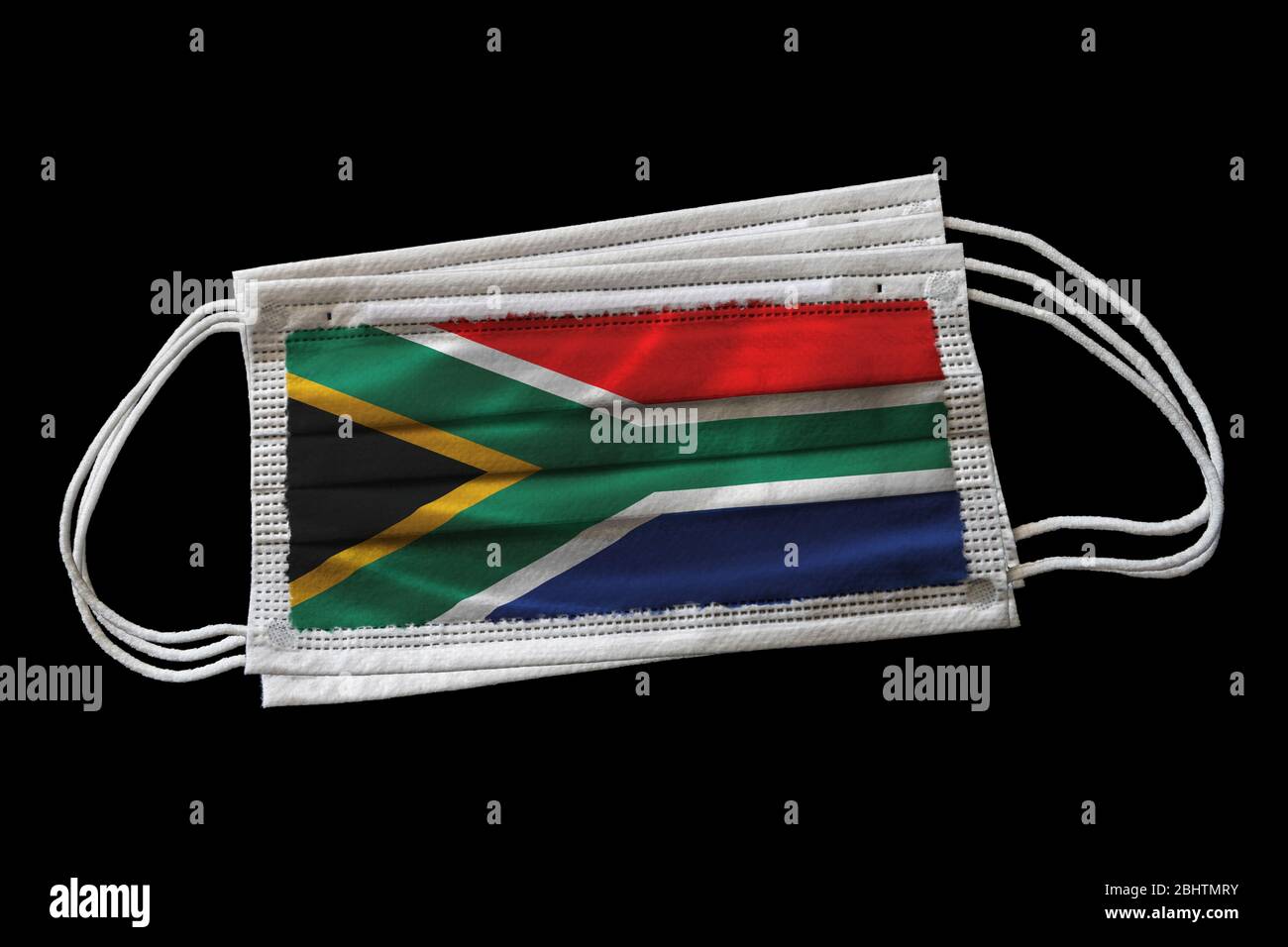 Chirurgische Gesichtsmasken mit Südafrika Flagge gedruckt. Isoliert auf schwarzem Hintergrund. Konzept der Gesichtsmaske Verwendung in Südafrika Bemühungen, Covid-1 zu bekämpfen Stockfoto