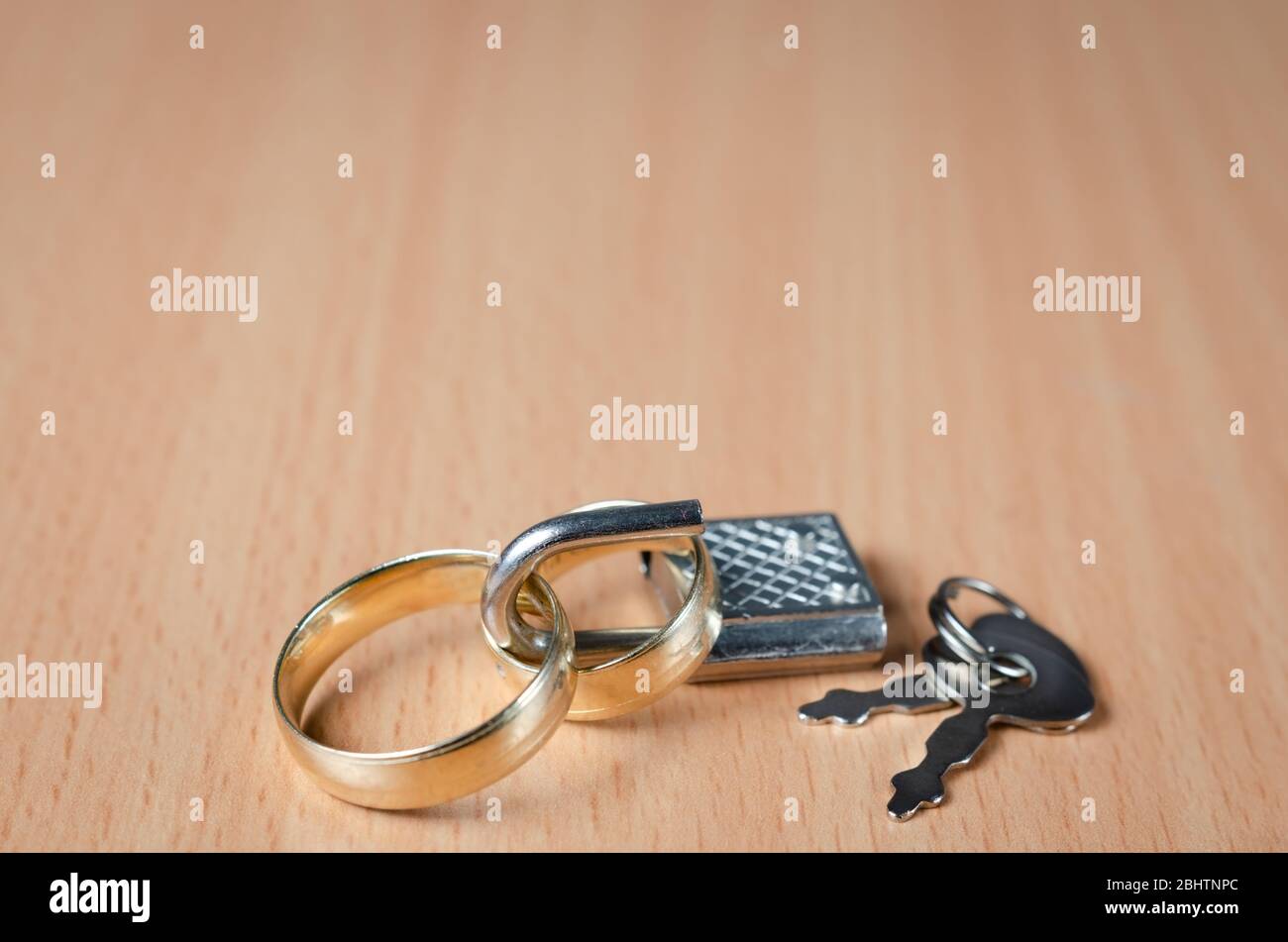 Nahaufnahme von zwei Eheringen mit einem Vorhängeschloss geschlossen, die ein Konzept der vereinigten Ehe ohne Geheimnisse und Vertrauen. Oder Scheidung zwischen tw Stockfoto