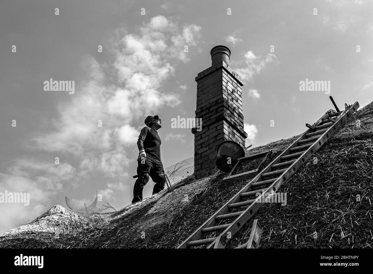 Thatcher auf dem Dach, Strohfotos, Handwerkerfotos, Dach Thatcher Fotos, Cottage Fotos, Haus Fotos, Fotos wiederherstellen, Weidenfotos, Stockfoto