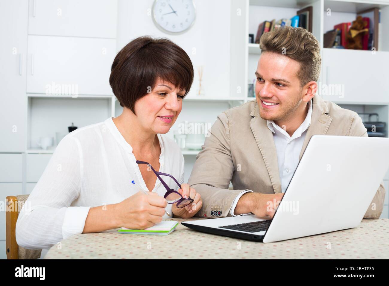 Lächelnde Mutter und Sohn neue Software auf dem Laptop am Tisch sitzen berücksichtigen Stockfoto