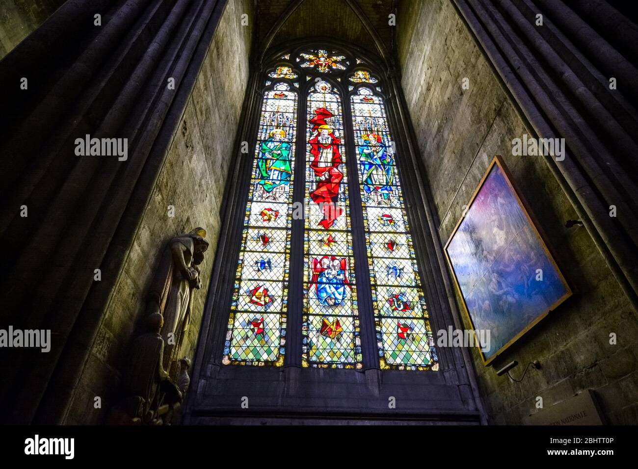 Glasfenster, Statue und Malerei im Inneren der Kathedrale von Rouen in Rouen Frankreich mit hell leuchtenden Farben an den Wänden Stockfoto