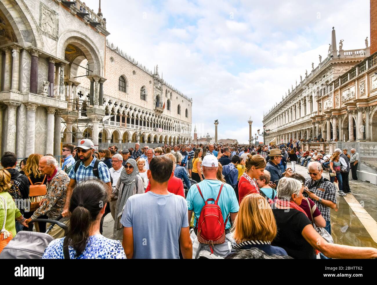 Die sichtbaren Auswirkungen des Übertourismus, da Kreuzfahrtschiffpassagiere an einem geschäftigen Tag in Venedig den Gang am Dogenpalast auf dem Markusplatz drängen Stockfoto