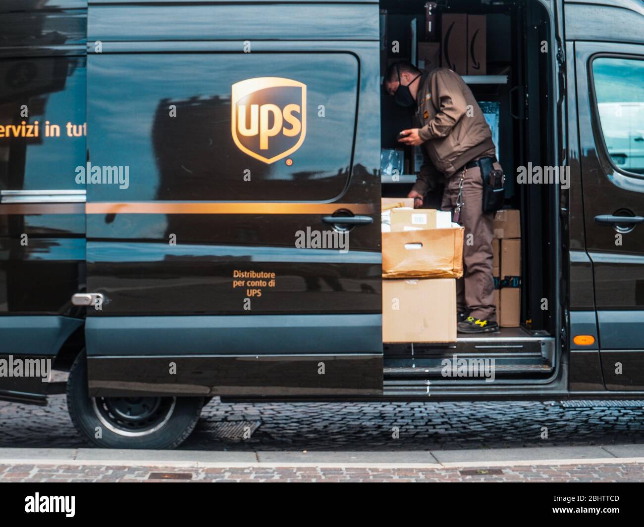 Cremona, Lombardei, Italien - 26. Und 27. April 2020 - ein UPS-Kurier liefert Pakete und Letterrs in einer verlassenen Stadt während des Coronavirus-Ausbruchs lo Stockfoto