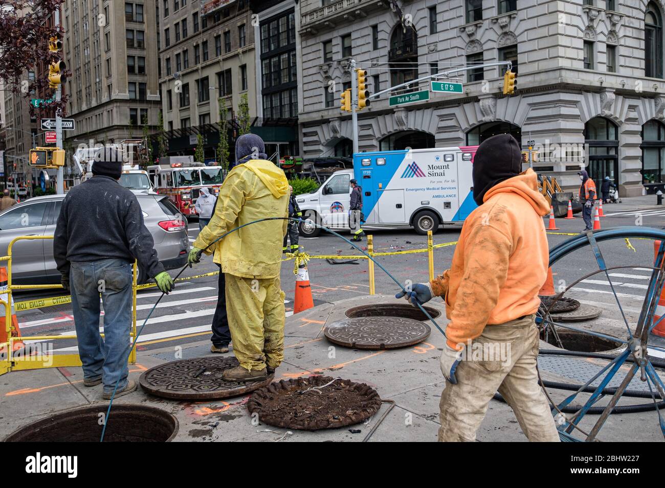 New York, USA. April 2020. Bauarbeiter beobachten am Montag, den 27. April 2020, wie sich EMT und Mitglieder der FDNY an der Ecke East 17th Street und Park Avenue South in der Nähe des Unions Square Park in New York, NY, USA, einem verletzten Motorradfahrer widmen. Trotz eines Rückgangs der meisten Arten von Verletzungen in Bewegung und Verkehrsunfälle in NYC seit Beginn der COVID-19 "Sperre" der Stadt, NYPD Berichterstattung hat eine deutliche Zunahme der übermäßigen Geschwindigkeitsverletzungen in der ganzen Stadt festgestellt. (Foto von Albin Lohr-Jones/Sipa USA) Quelle: SIPA USA/Alamy Live News Stockfoto