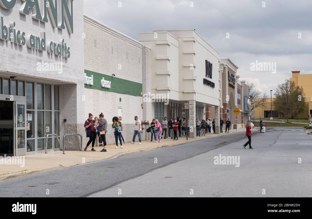 Berks County, Pennsylvania, USA, 26. April 2020- Menschen soziale Distancie während der Wartezeit in einer langen Schlange, um Joann Fabric zu betreten. Stockfoto