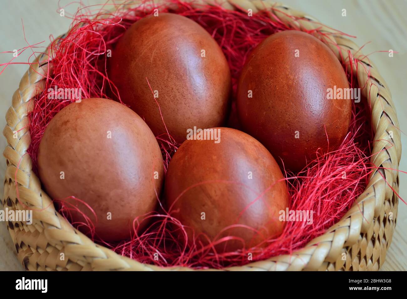 Schön gefärbte Hühnereier liegen in einem Weidenkorb Stockfoto