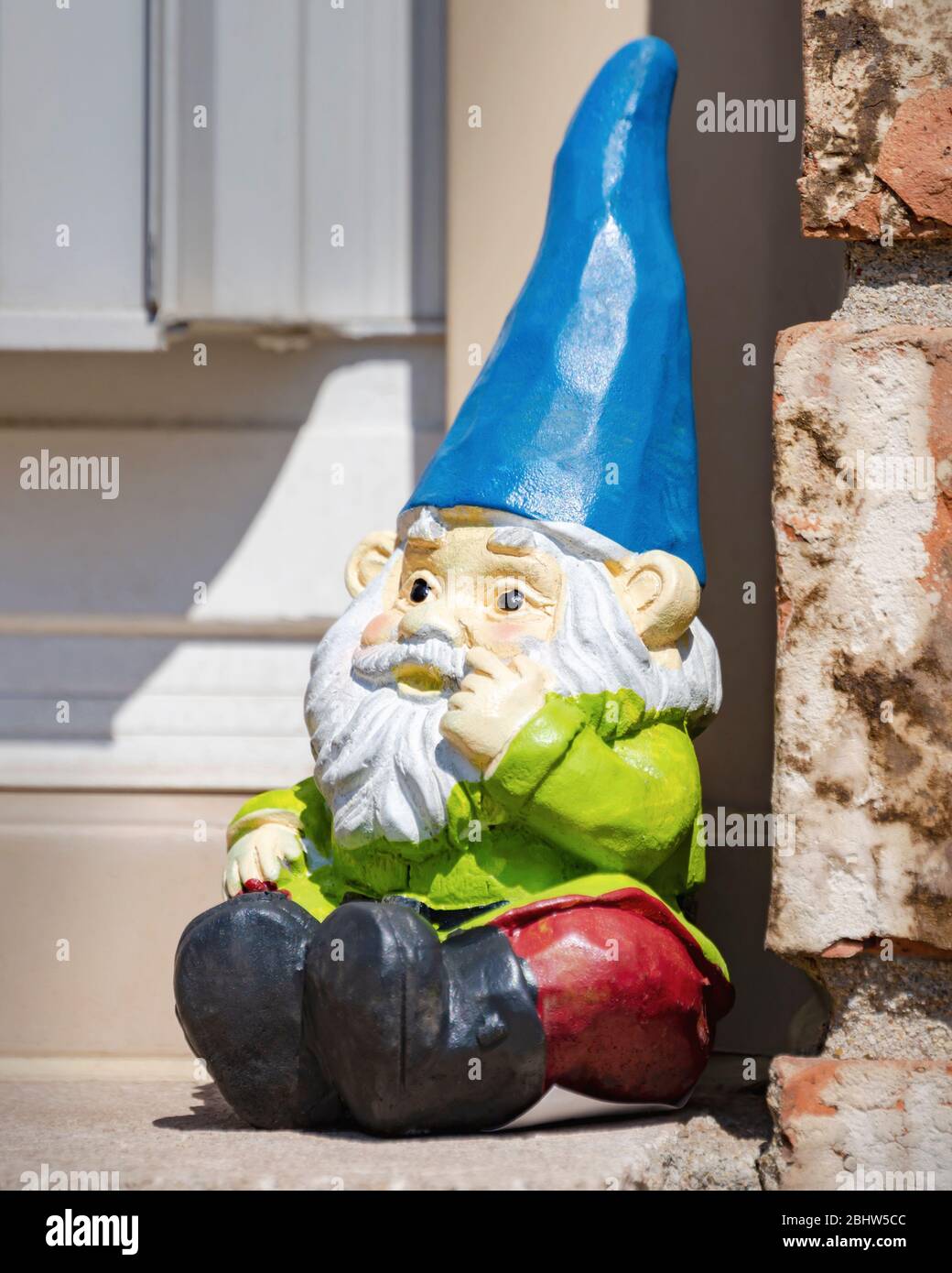 Garten Gnom sitzen auf Fensterbank draußen. Stockfoto