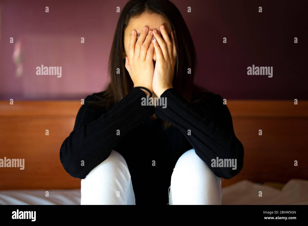 Traurige und überforderte Frau mit Händen auf ihrem Gesicht. Depressionskonzept. Stockfoto