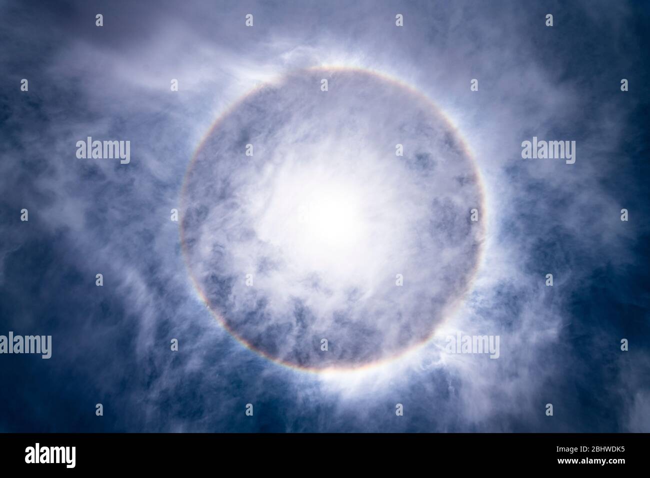 Die Sonne, mit einem erstaunlichen Halo um die Sonne durch Lichtbrechung wegen Eiskristalle auf den oberen Atmosphärenschichten in der Troposphäre erstellt Stockfoto