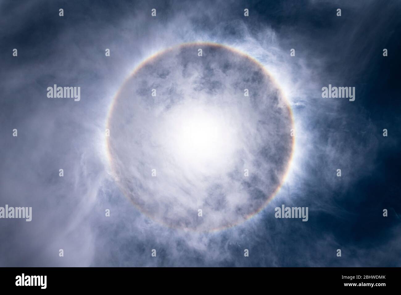 Die Sonne, mit einem erstaunlichen Halo um die Sonne durch Lichtbrechung wegen Eiskristalle auf den oberen Atmosphärenschichten in der Troposphäre erstellt Stockfoto