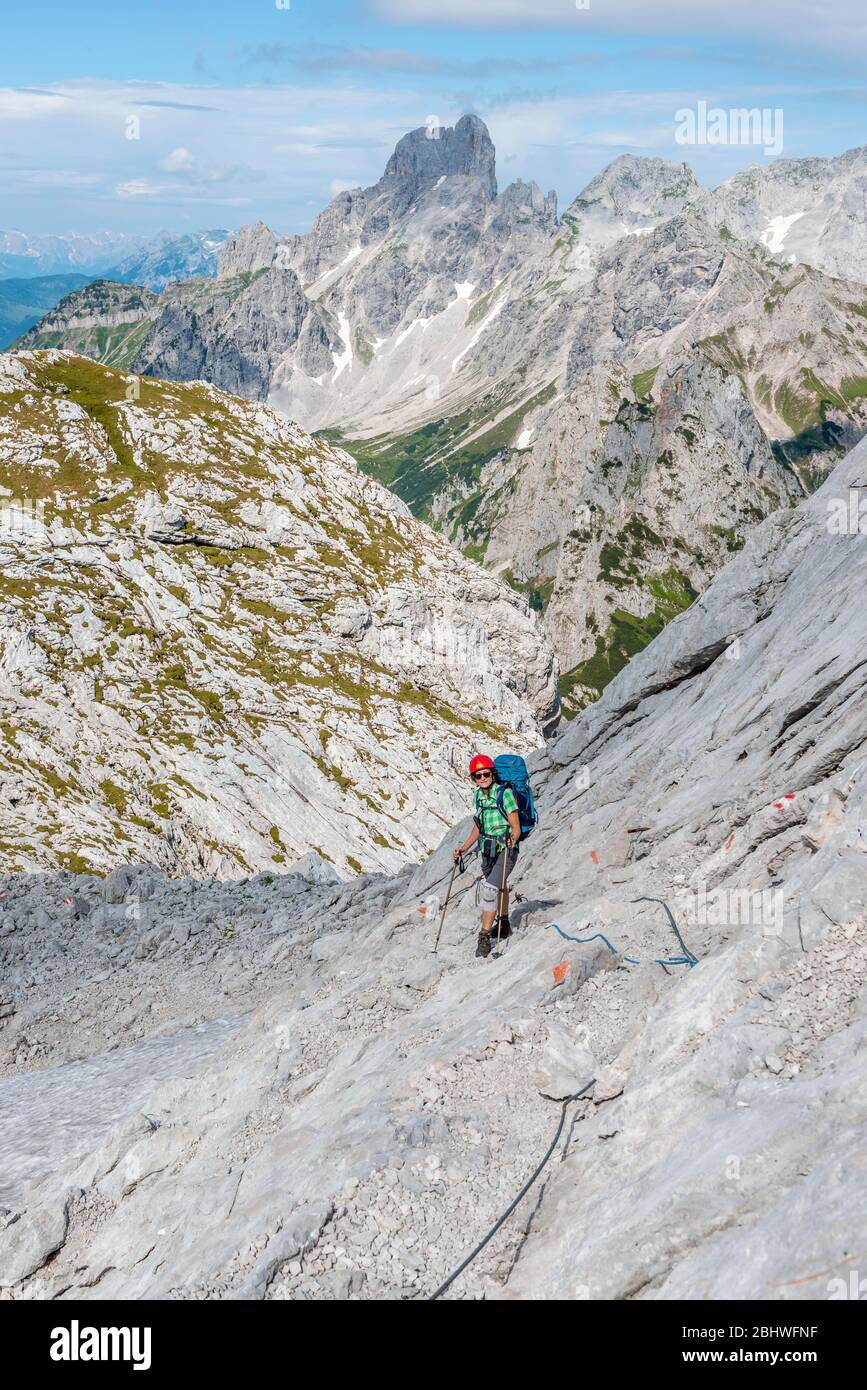 Wanderer auf einer mit einem Seil gesicherten Felskette von Simonyhütte nach Adamekhütte, felsiges alpines Gelände, Blick auf das Bergpanorama und Vorderer Stockfoto