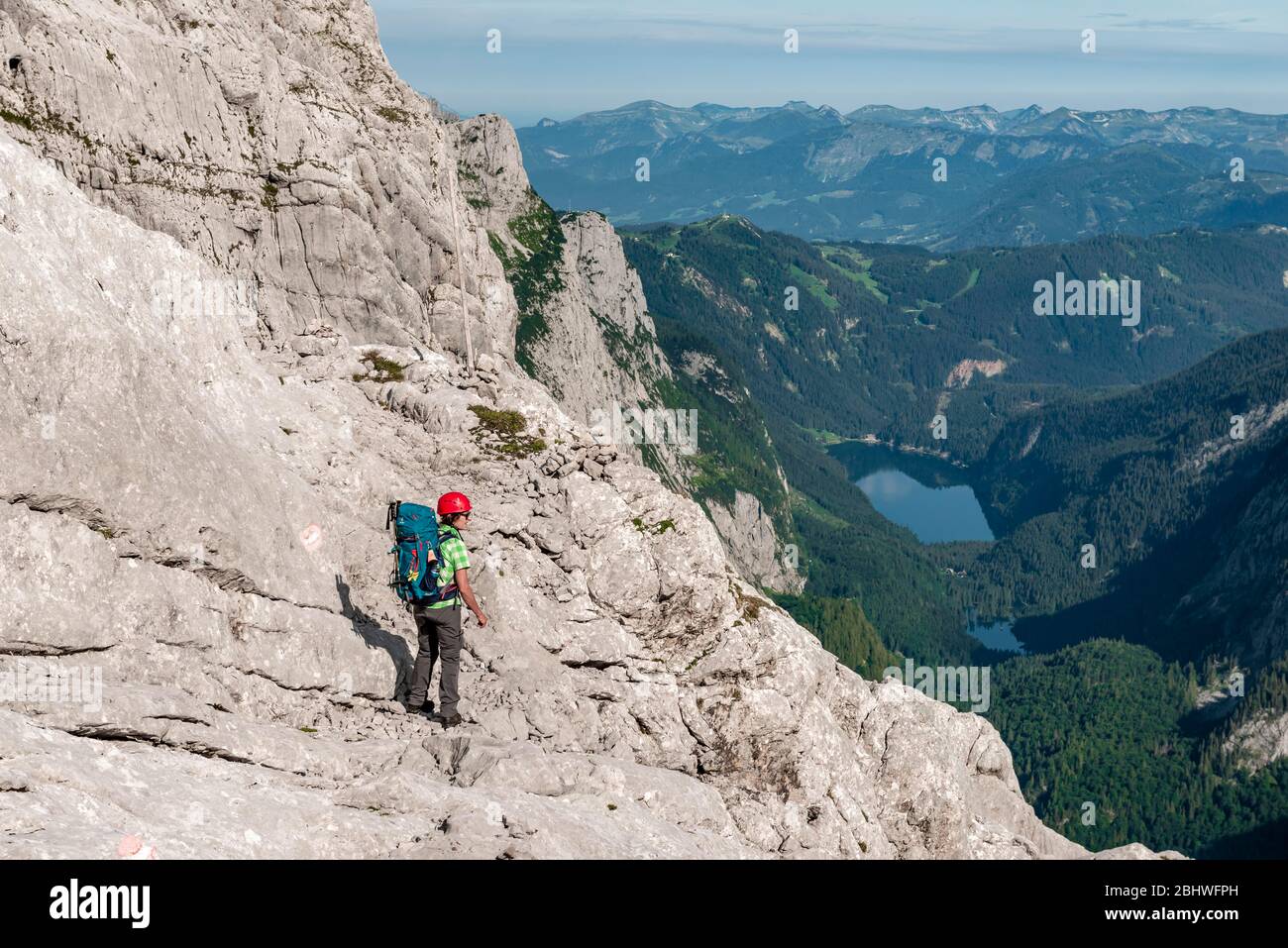 Wanderer auf felsiger Route von Simonyhütte nach Adamekhütte, felsiges alpines Gelände, Blick auf Bergpanorama und Vorderer Gosausee, Salzkammergut, Obere Stockfoto