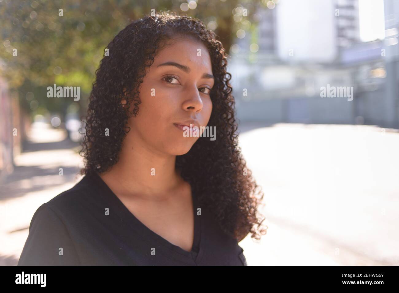 Schwarze Frau auf urbanem Hintergrund in Freizeitkleidung Stockfoto