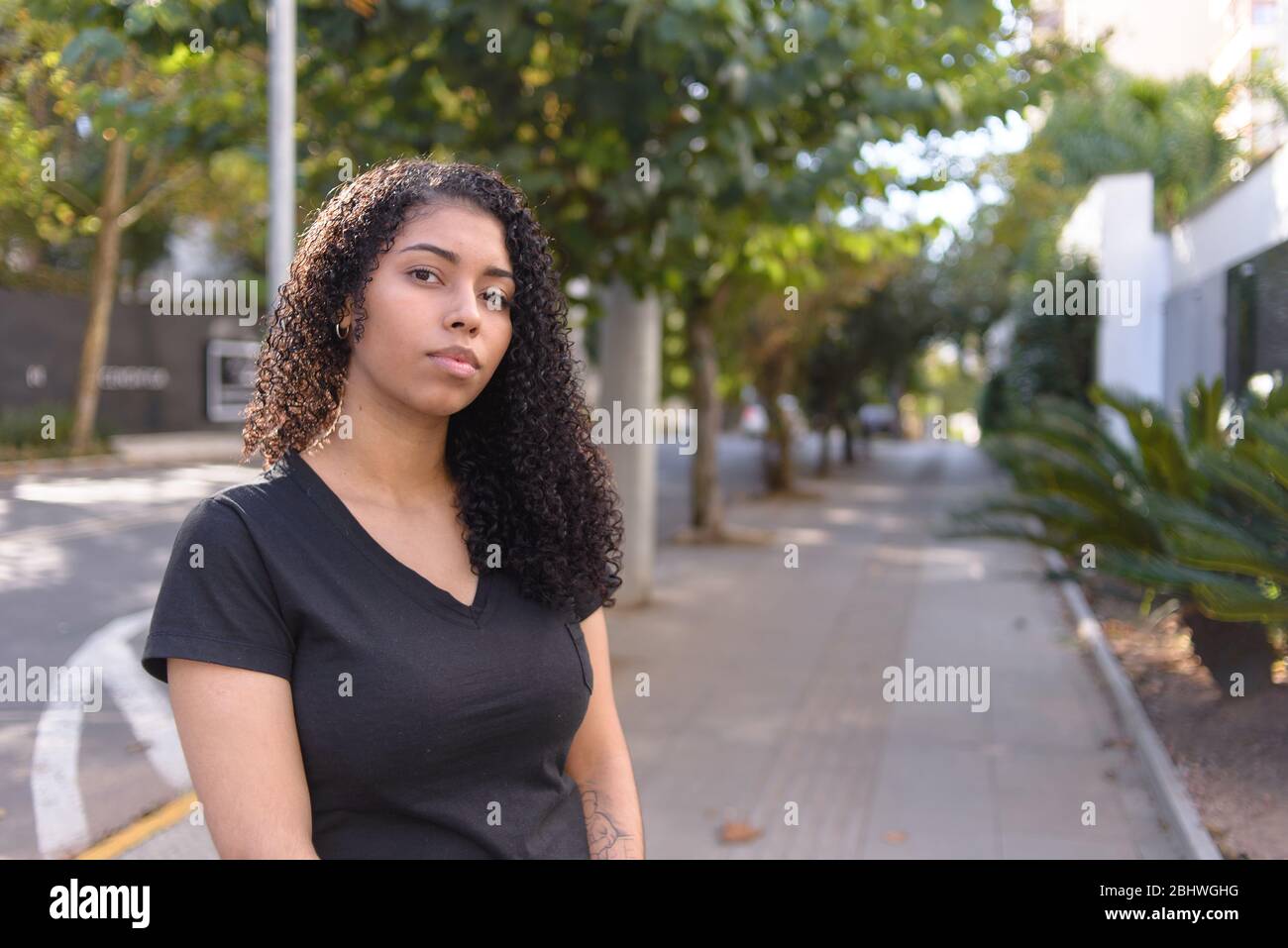 Schwarze Frau auf urbanem Hintergrund in Freizeitkleidung Stockfoto