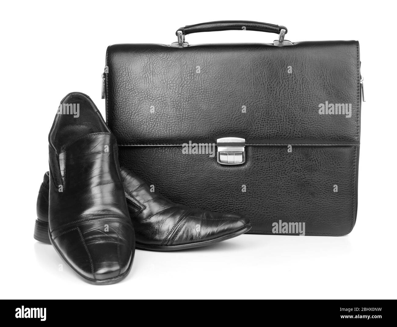 Aktentasche aus schwarzem Leder mit Schuhen isoliert auf weiß Stockfoto