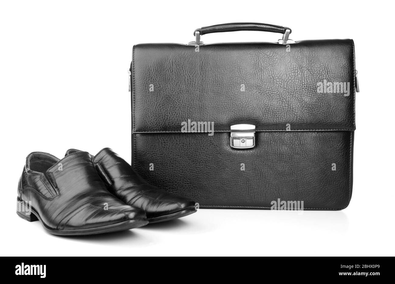 Aktentasche aus schwarzem Leder mit Schuhen isoliert auf weiß Stockfoto