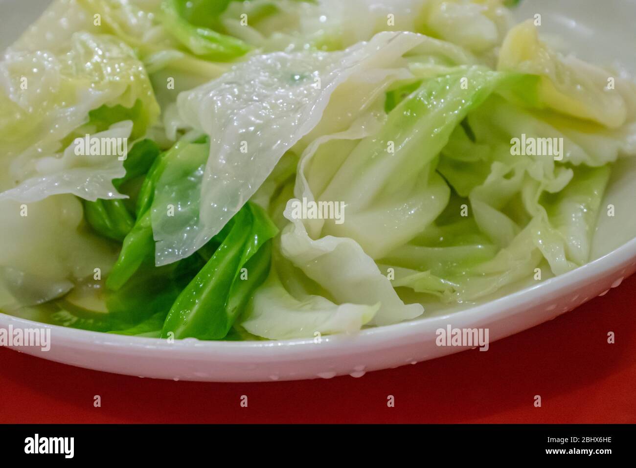 Die Nahaufnahme von köstlichem gebratenem Kohl auf weißem Teller im taiwanesischen Restaurant. Stockfoto