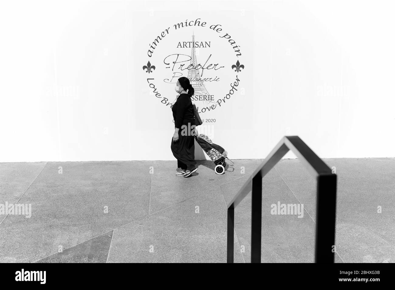 Singapur - April 19 2020: Asiatische Frau, die während der COVID-19 mit chirurgischer Maske in Clementi Central, Singapur, läuft Stockfoto