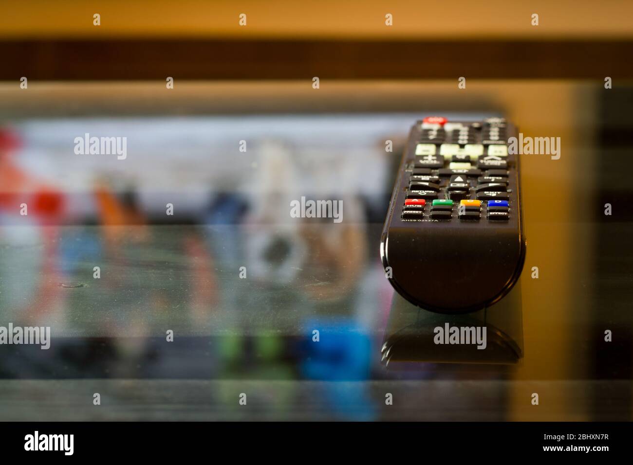 TV-Fernbedienung auf dem Glastisch, bereit für Film oder Serie Stockfoto