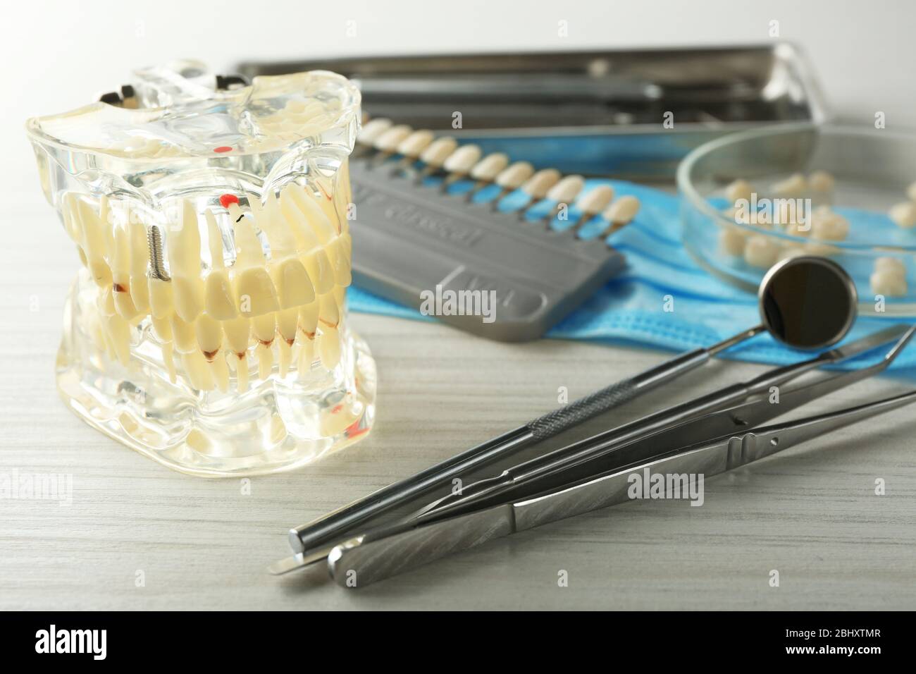 Zahnersatz, Prothese und zahnärztliche Instrumente auf Tischhintergrund Stockfoto