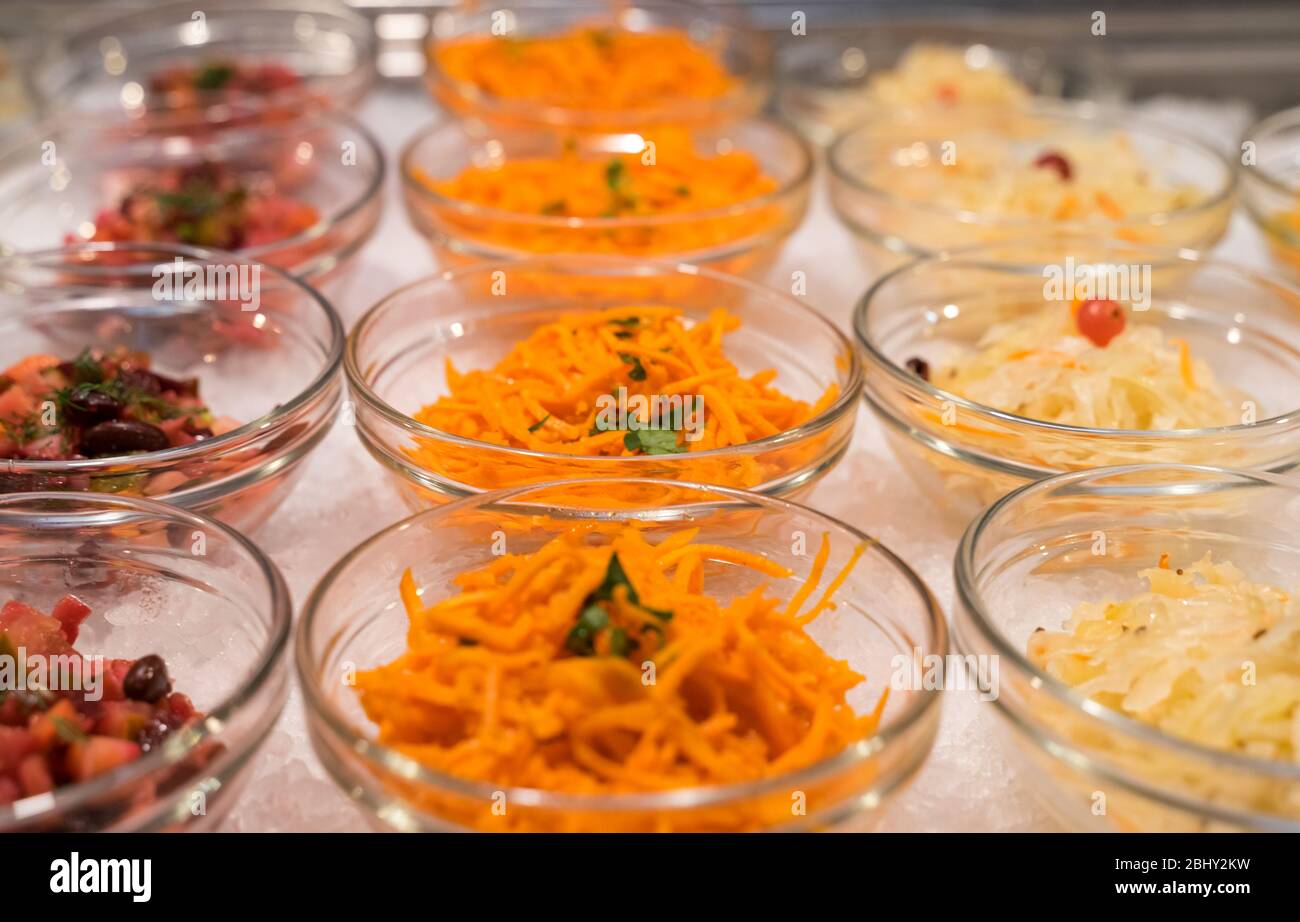 Salate in Schüsseln in der offenen Küche des Restaurants sind in einer Reihe Stockfoto