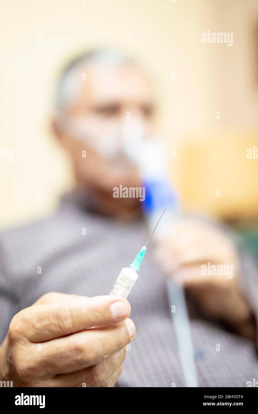 Leitender Mann, der medizinische Geräte für die Inhalation mit Atemschutzmaske verwendet, Vernebler im Zimmer Stockfoto