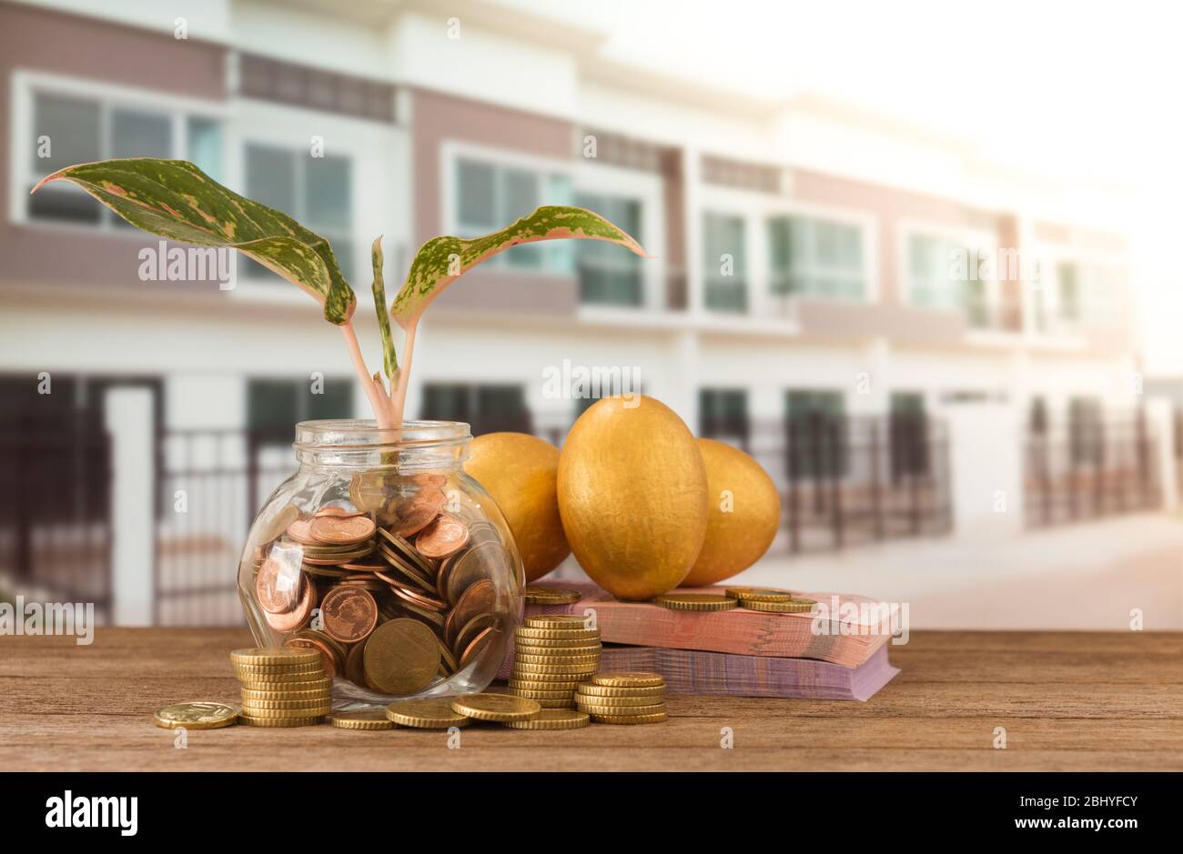 Münzen Glas mit Sprossen wachsen, Banknote, goldene Eier, goldene Münze auf neuen Stadthaus Hintergrund. Konzept der Investitionsimmobilien. Konzept der Steuerplanung von Stockfoto