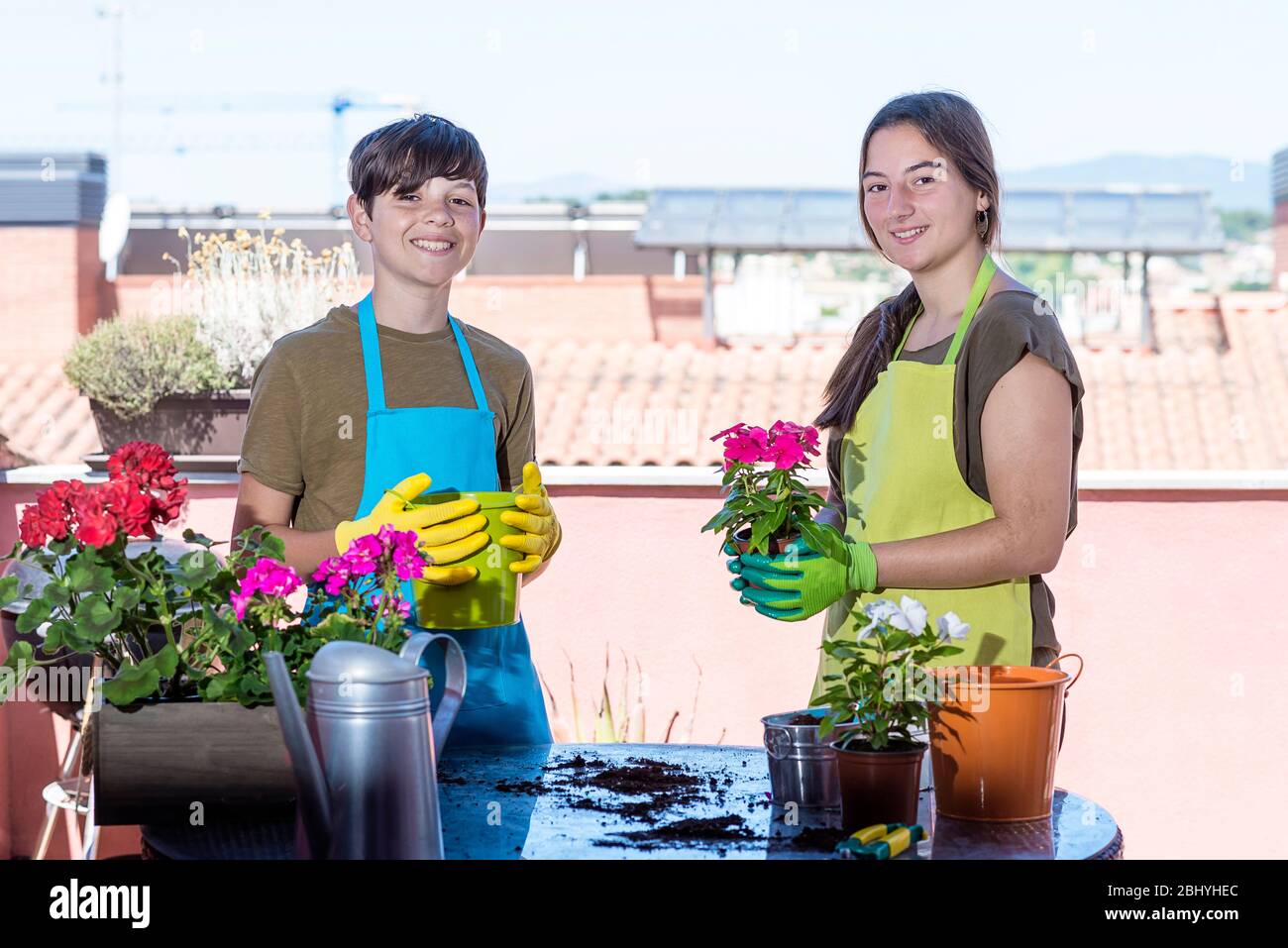 Zwei Teenager tragen Gärtner Schürze posiert auf der Terrasse zu Hause Stockfoto