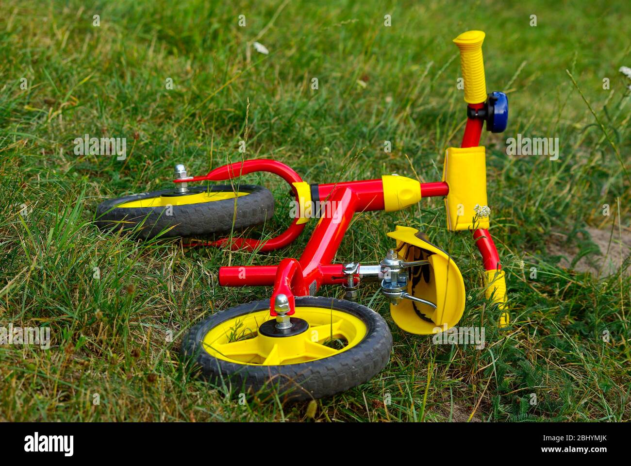 Ein rotes Fahrrad für Kleinkinder im Gras liegen. Stockfoto