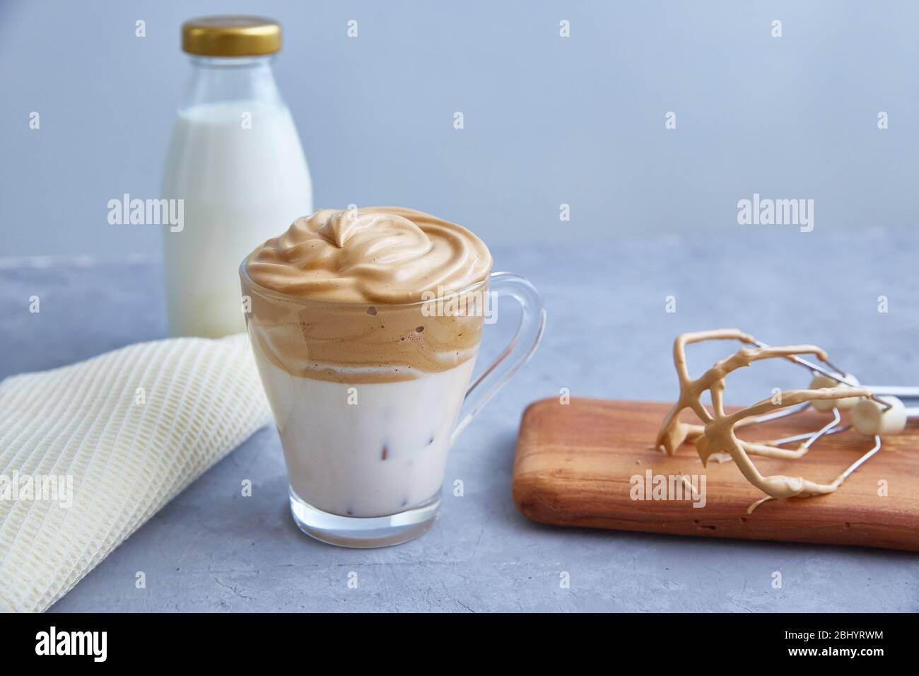 Dalgona Kaffee auf grauem Hintergrund. Modisches Getränk mit flauschiger cremiger Basis aus Milch, Kaffee und Zucker. Kopierbereich. Stockfoto