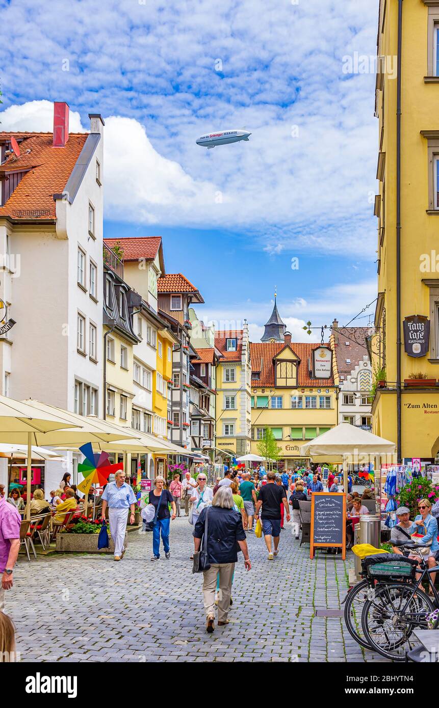 Stadtszene auf der Maximilianstraße mit Werbezeppelin über der historischen Altstadt von Lindau im Bodensee, Bayern, Deutschland, Europa. Stockfoto